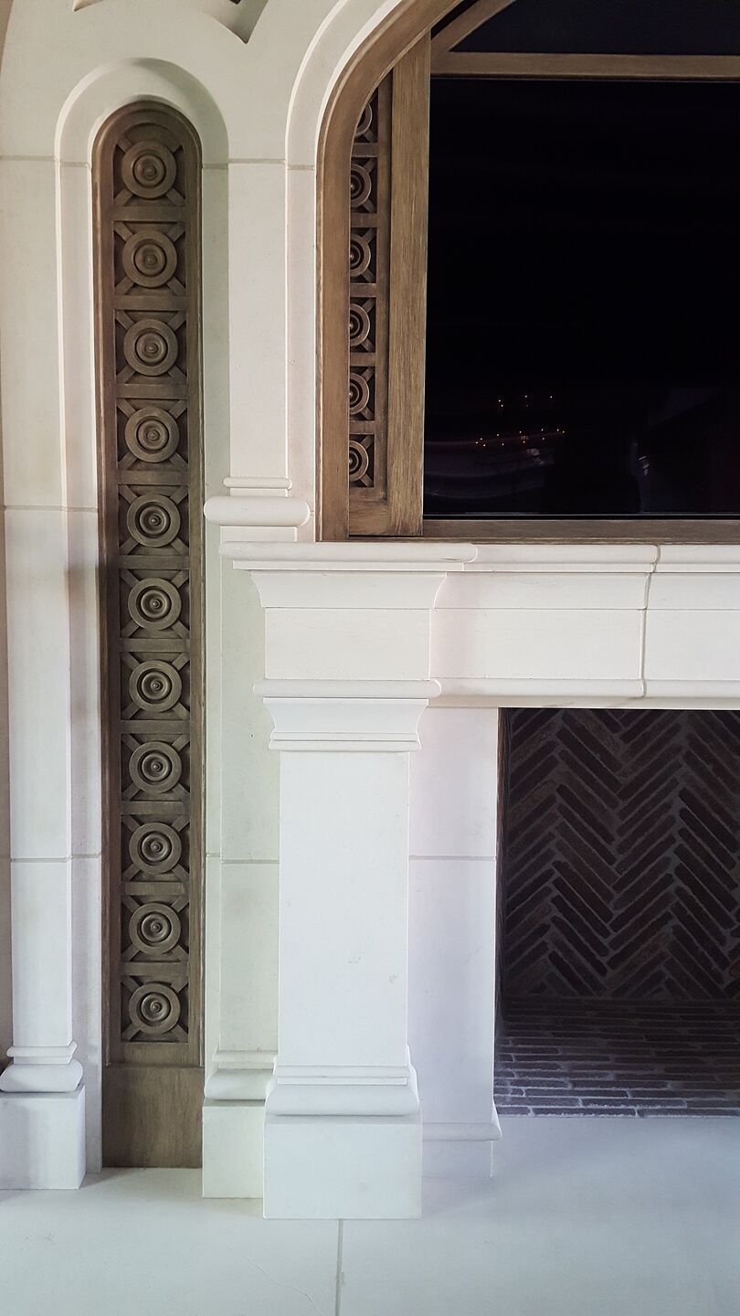 Living room with stunning fireplace design, and media center with custom hand-carved doors.