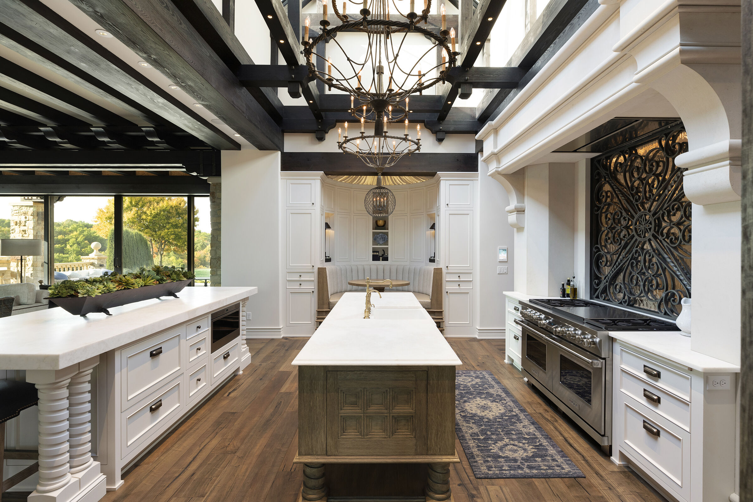 Stunning kitchen design. Skylight ceiling for natural light, beautiful wood beam details. Custom cabinetry with hand-carved wood door details. Kitchen island, breakfast nook, custom metal and glass backsplash. Gorgeous interior architecture details.