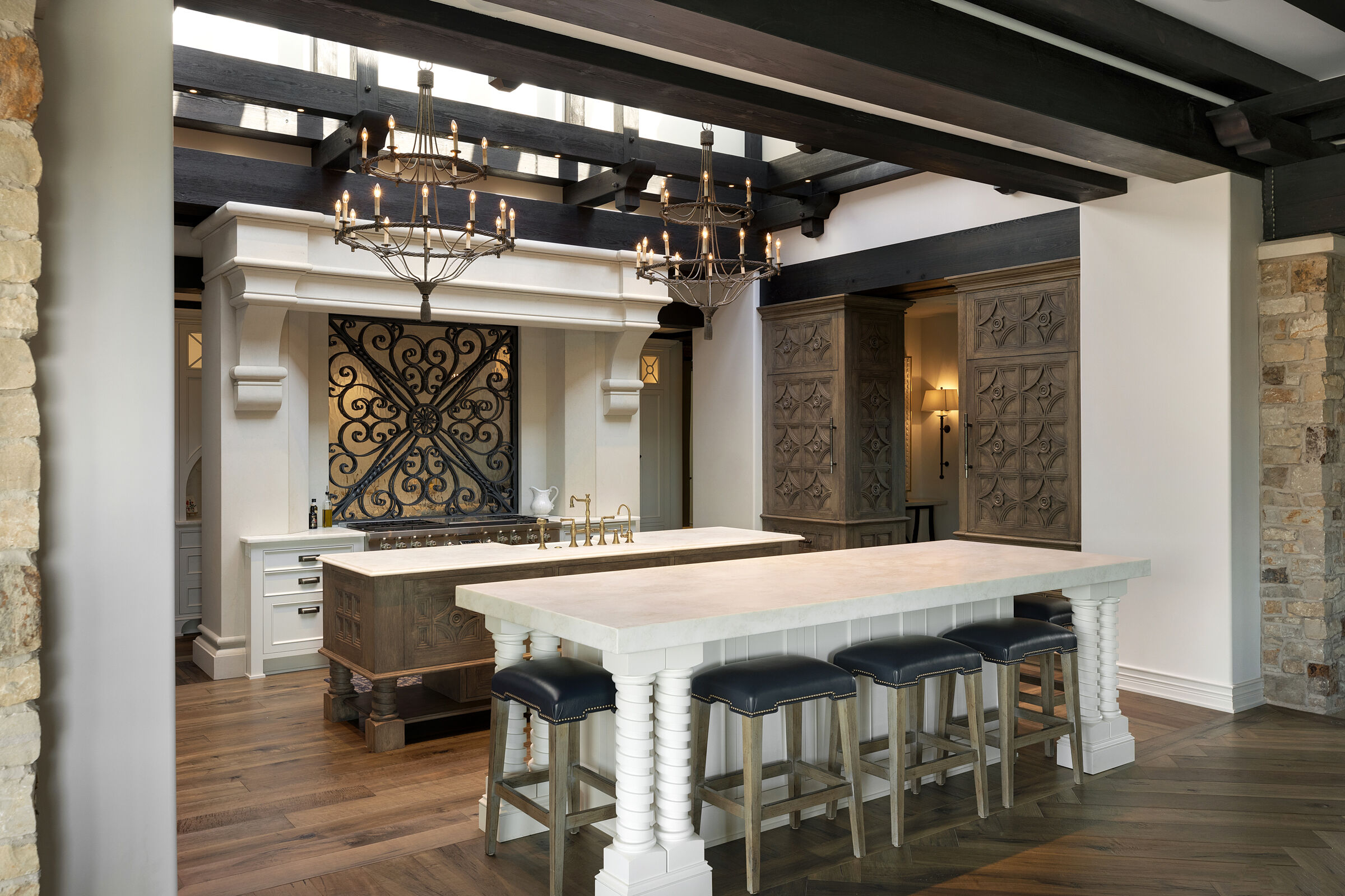 Stunning kitchen design. Skylight ceiling for natural light, beautiful wood beam details. Custom cabinetry with hand-carved wood door details. Kitchen island, breakfast nook, custom metal and glass backsplash. Gorgeous interior architecture details.