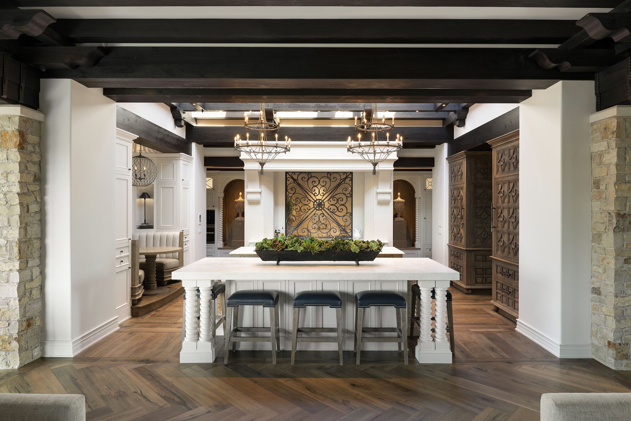 Stunning kitchen design. Skylight ceiling for natural light, beautiful wood beam details. Custom cabinetry with hand-carved wood door details. Kitchen island, breakfast nook, custom metal and glass backsplash. Gorgeous interior architecture details.
