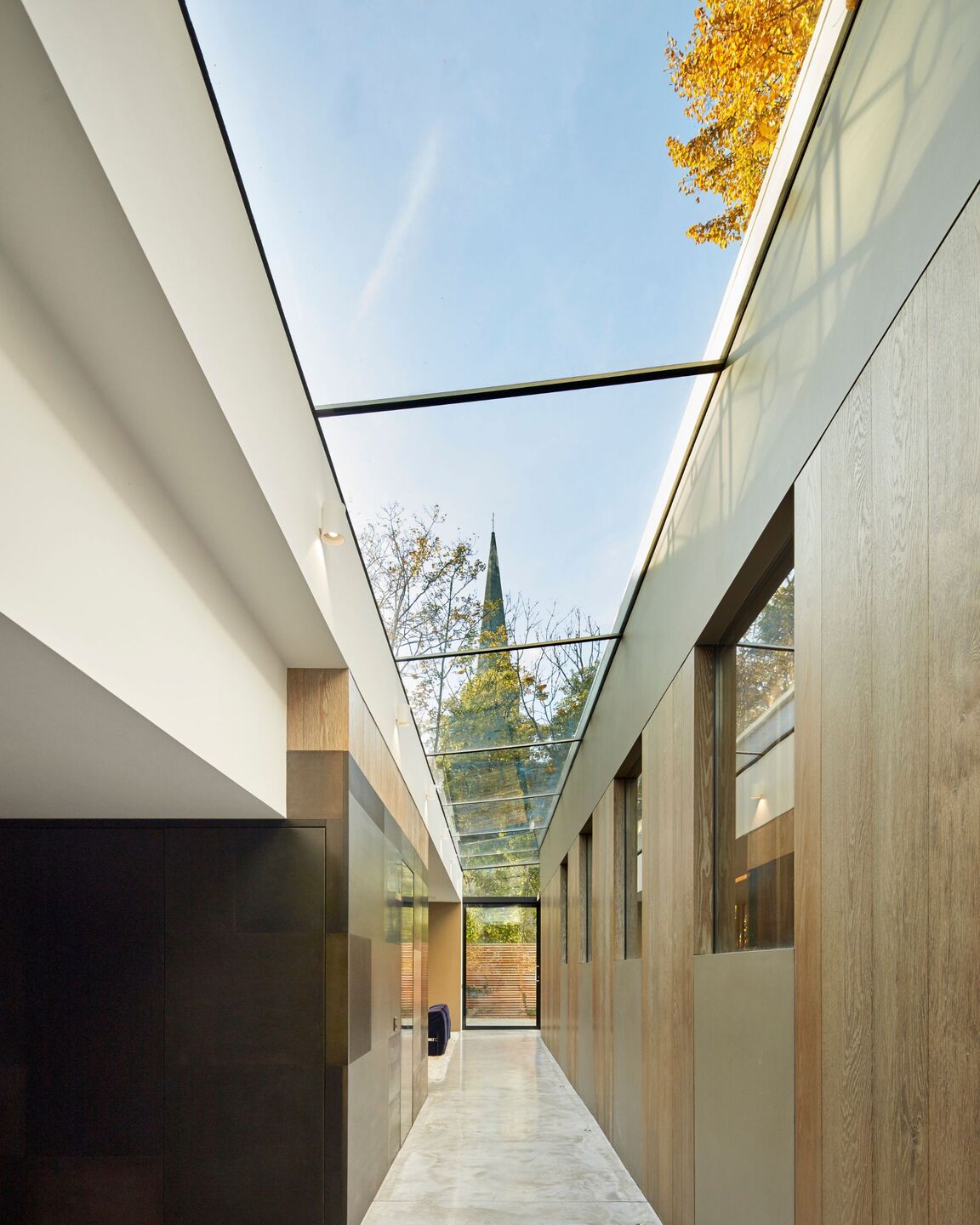 Light filled subterranean glass walkway provides room for a dedicated entertainment and wellness space.