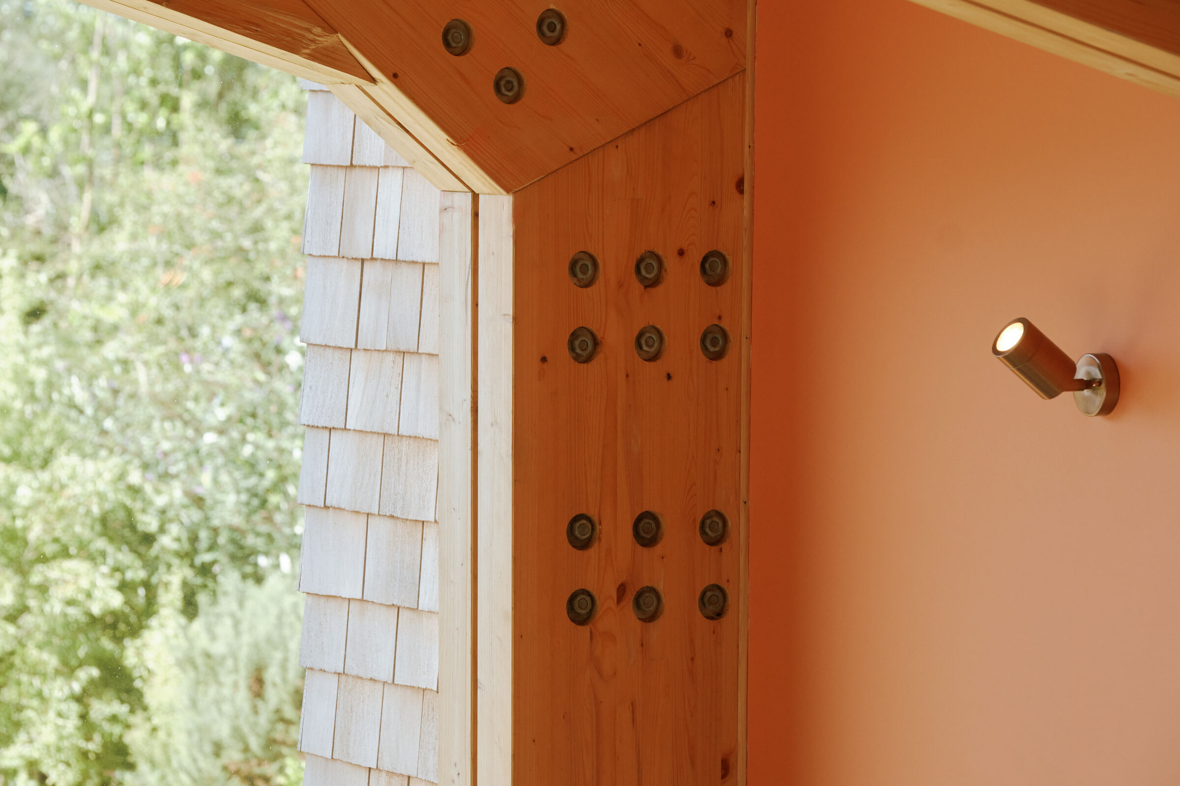 Close up of architectural glass interfacing with the timber and brickwork seamlessly.