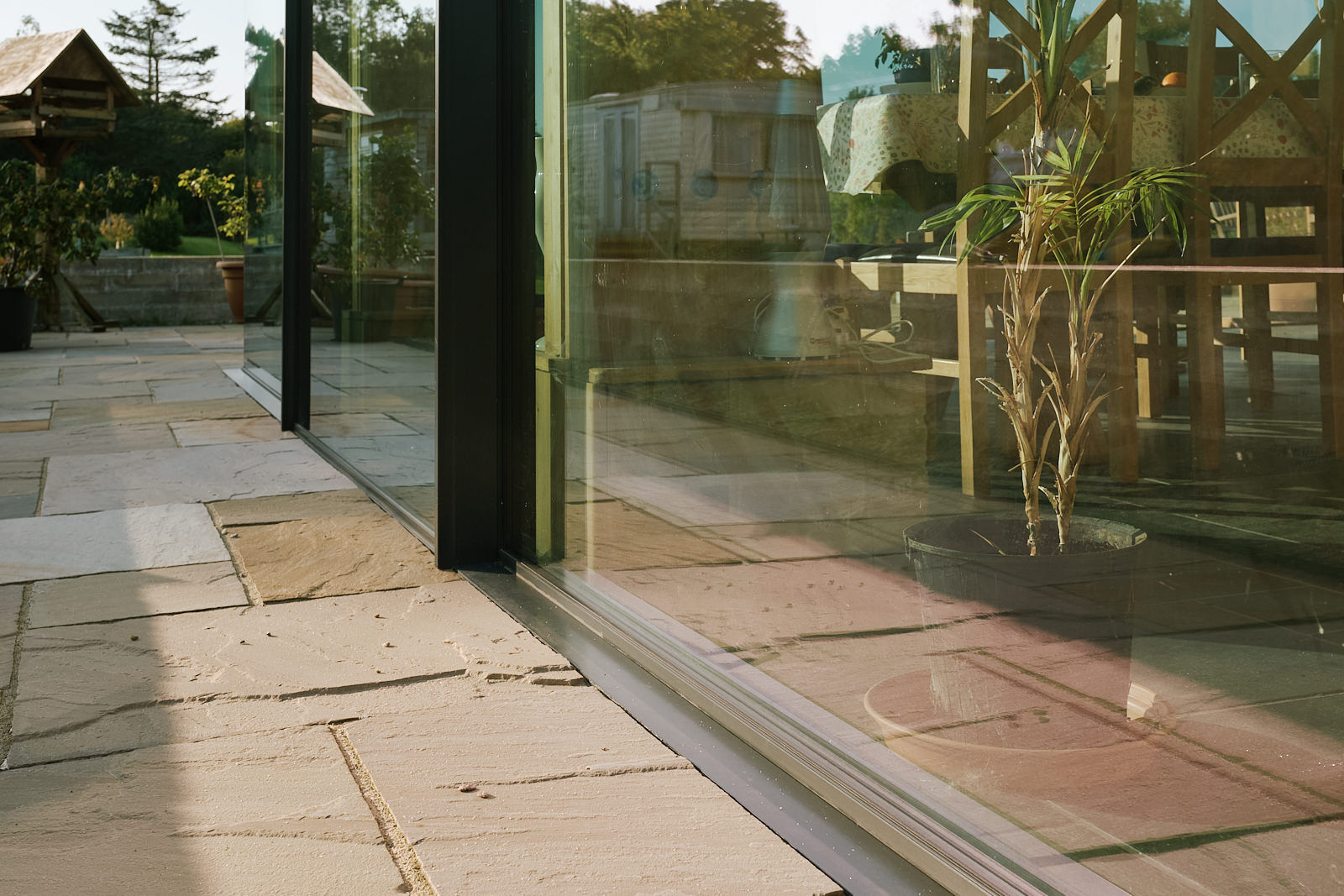 Base of sliding glass doors has flush thresholds for seamless transitions to the gardens.