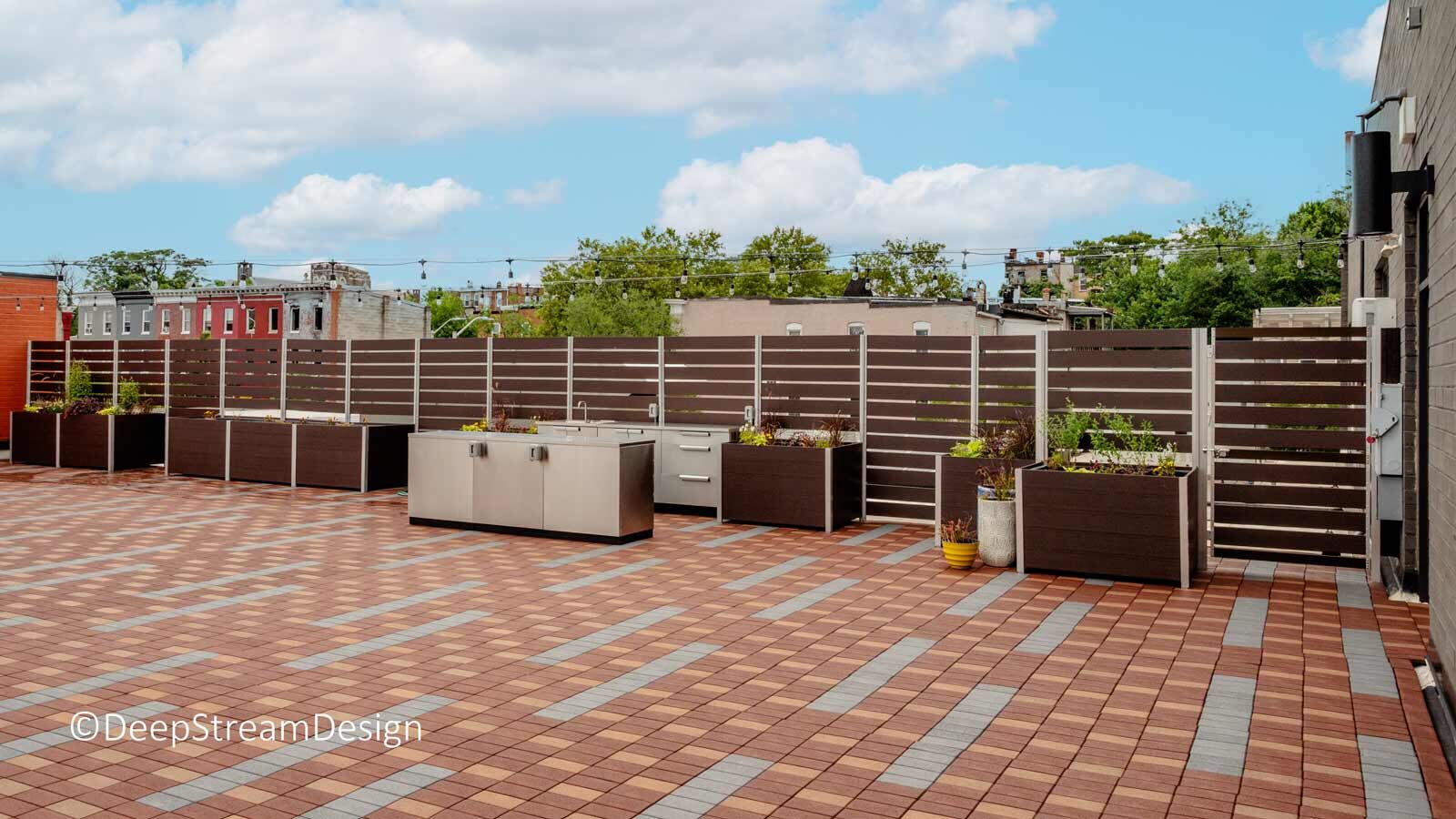Planter anchored screen wall with gate separates community space from rooftop solar