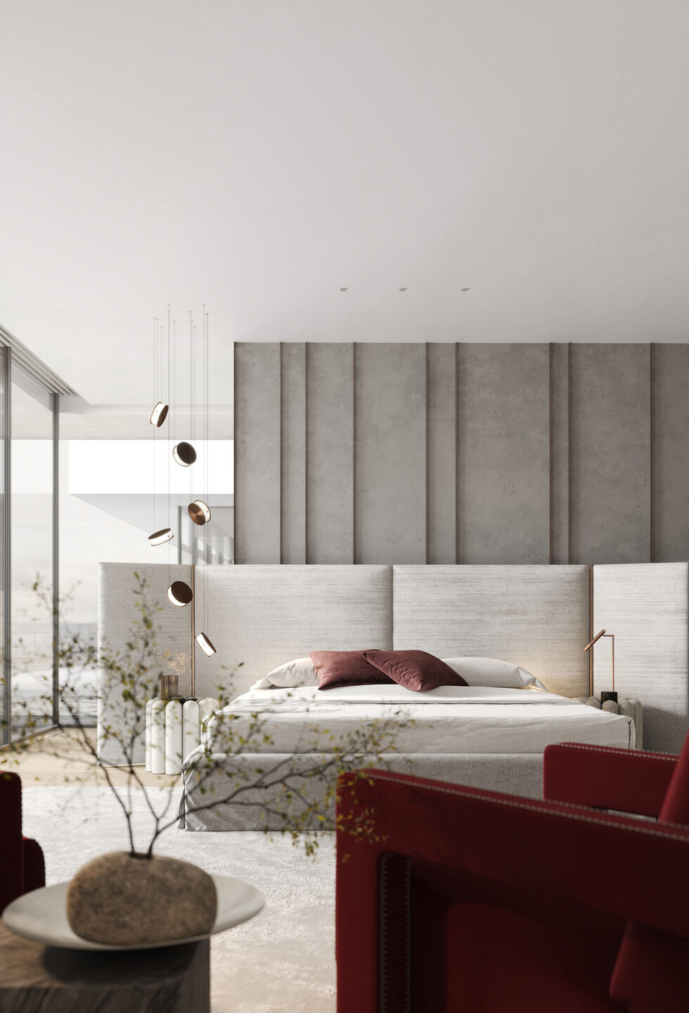 Textured concrete panels create a gentle rhythm across the wall, while deep red chairs add a personal note.