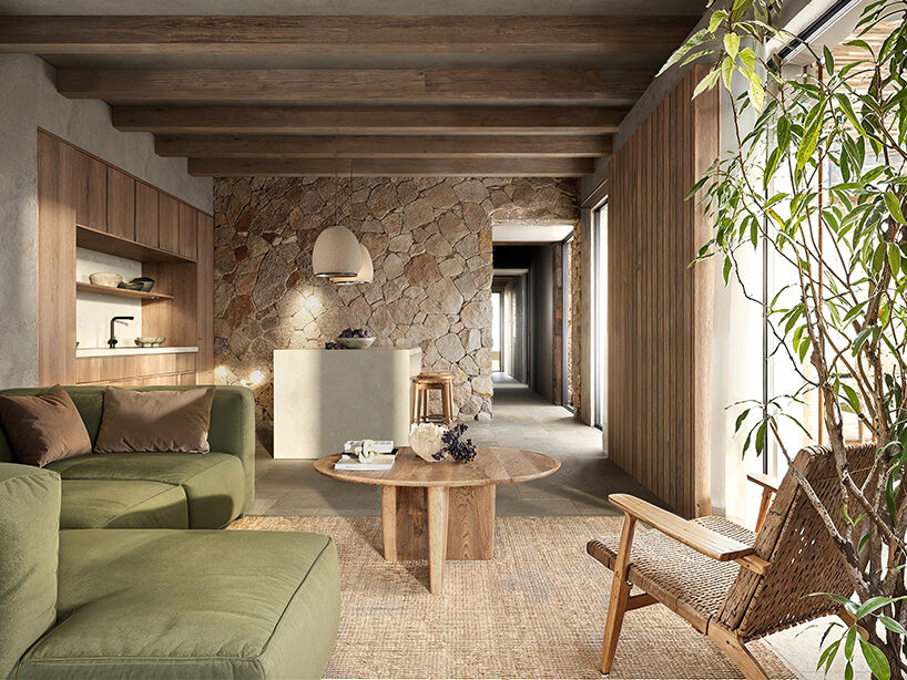 The living space transitions into a stone-lined corridor, highlighting the tactile material character of the interior.