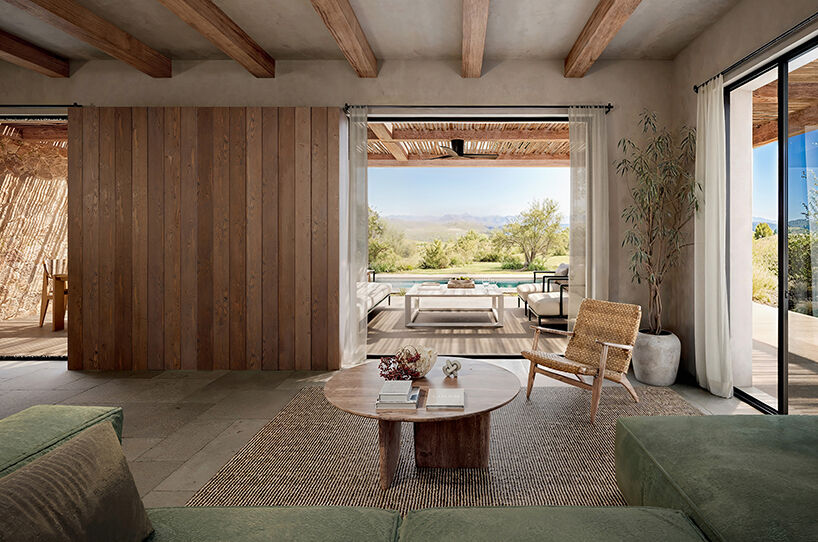 Wide openings dissolve the boundary between interior and exterior spaces, framing views toward the pool and landscape.