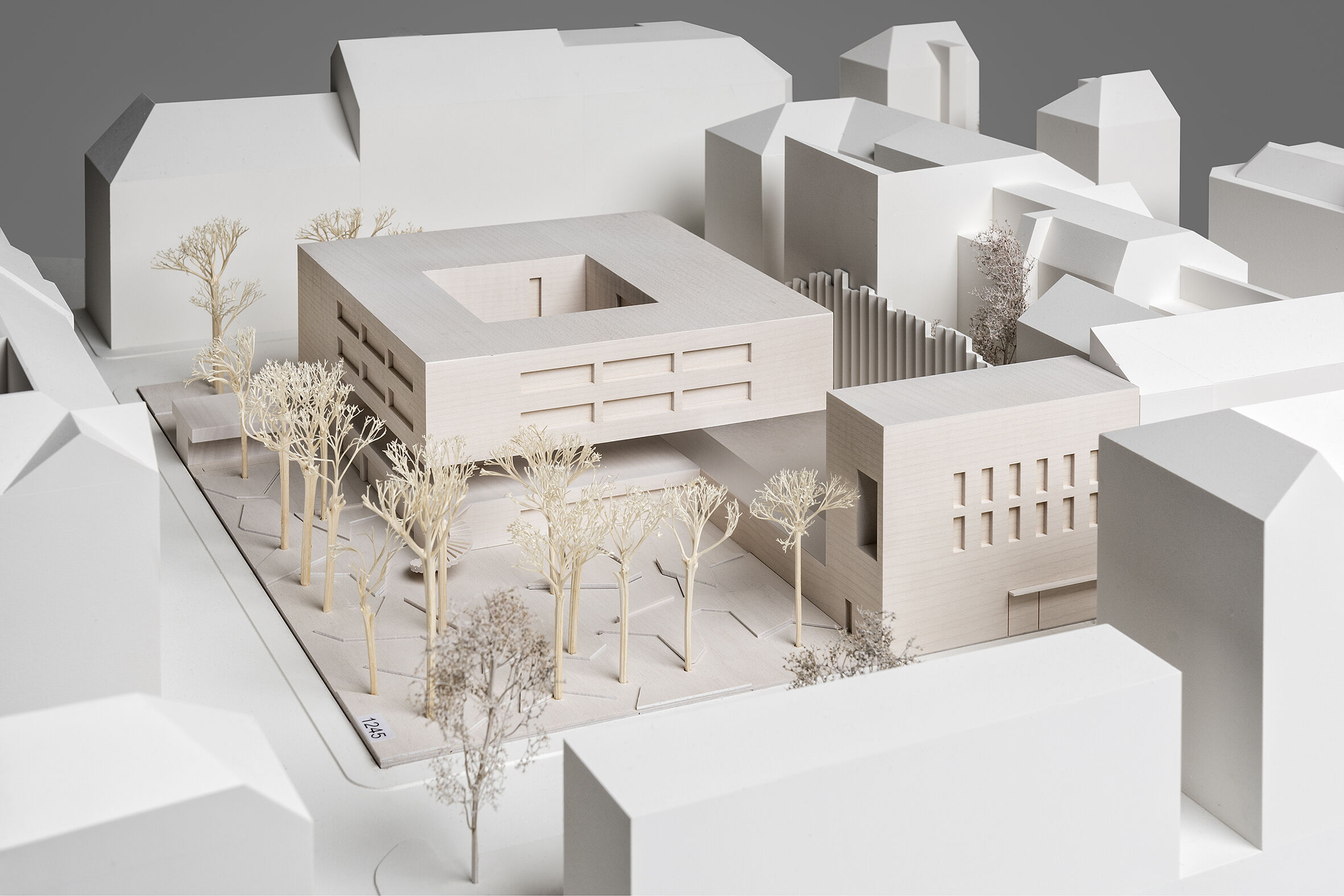 The embassy is enveloped by expansive landscaped grounds featuring mature trees.