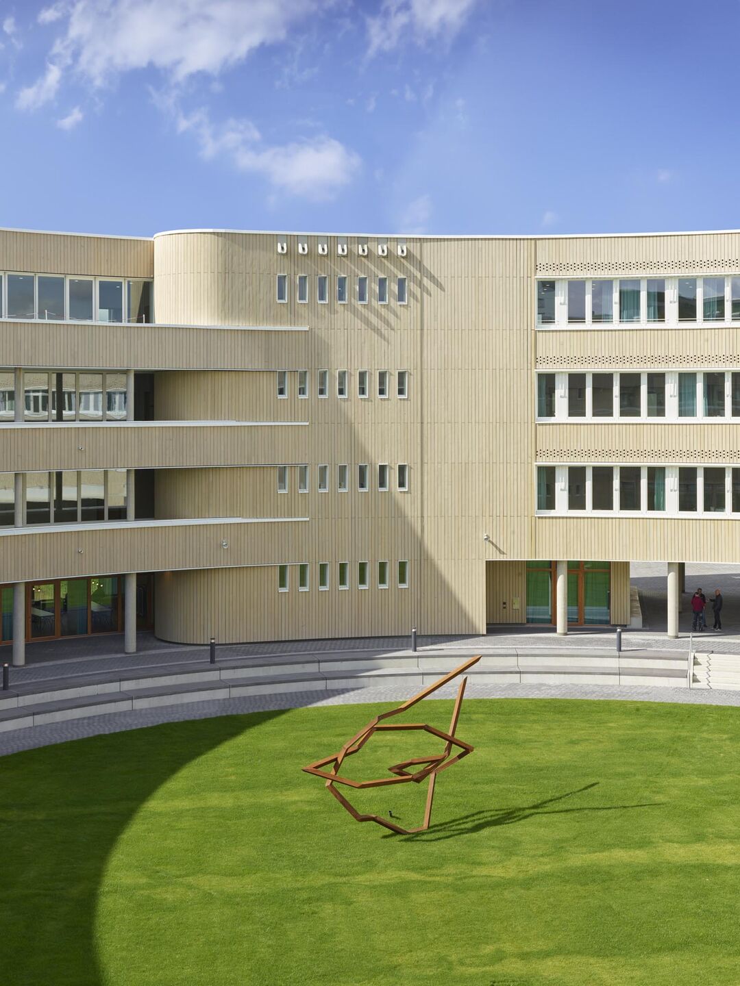 The circular shape creates a centre that enables intuitive navigation; it forms an attractive inner courtyard that invites visitors to linger and communicate. (Steal sculpture by Robert Schad, Larians/Chamosinhos)