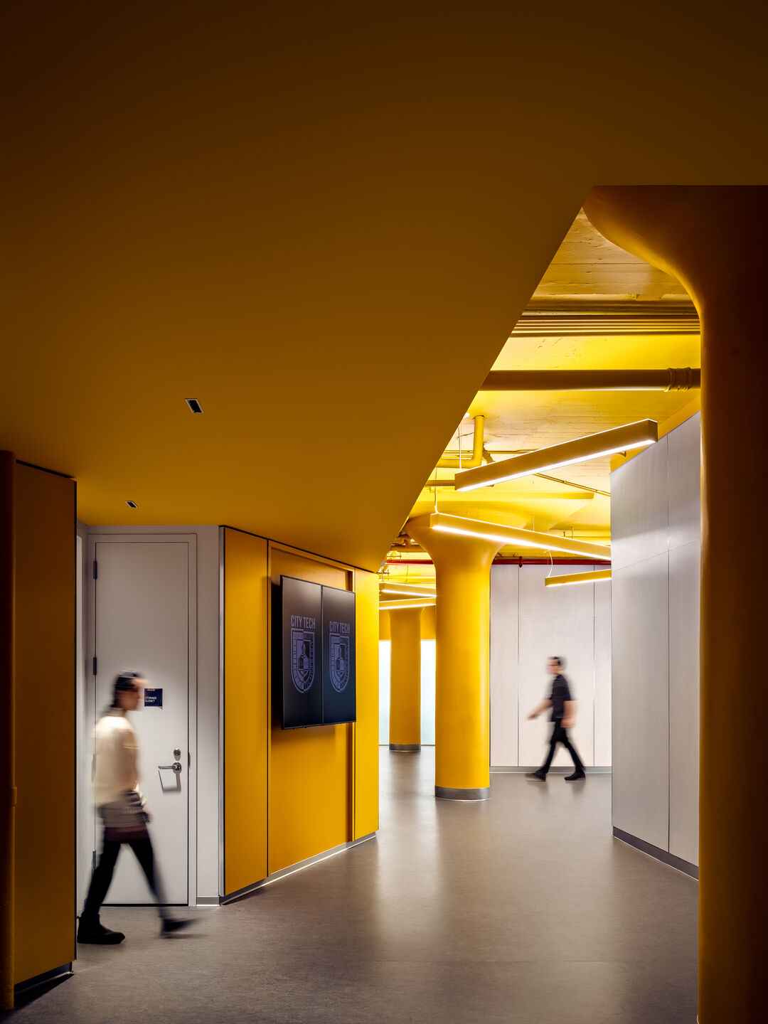 Playful lighting design and vibrant yellow walls and ceilings enliven this interior corridor.