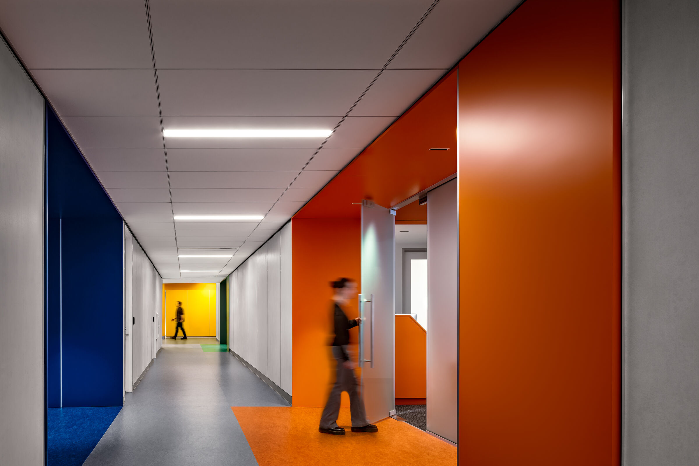 Colors established within suites extend outward into the hallway, inviting users into the space and assisting with wayfinding across the large floorplate.