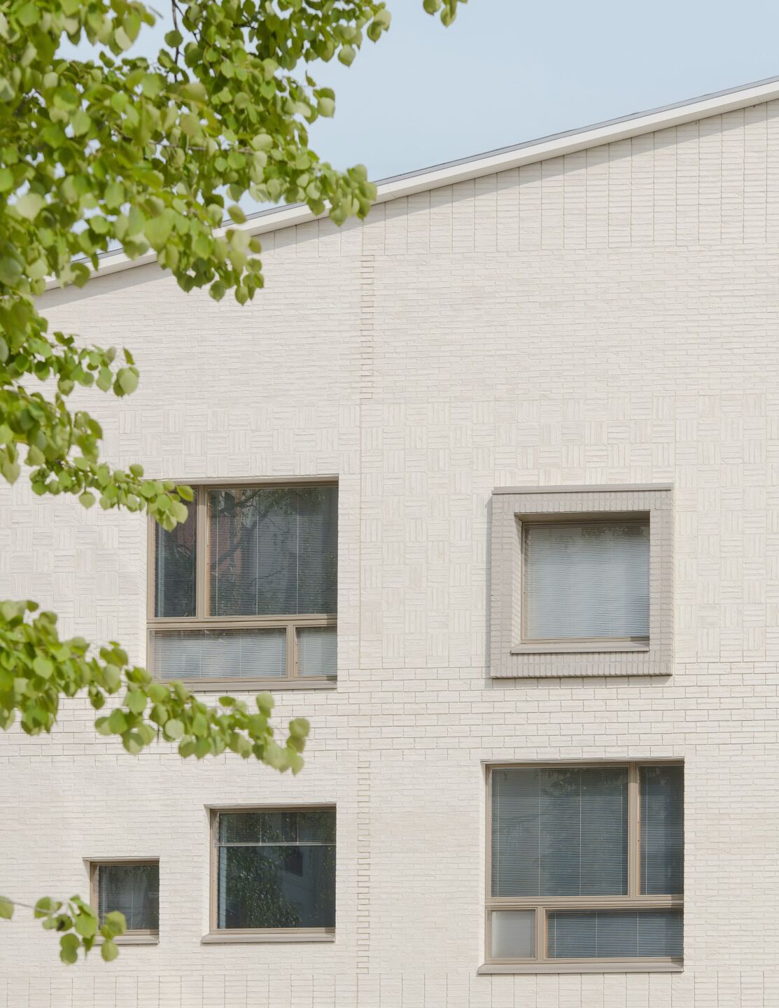 The facades clad in hand laid light brick are enlivened by combining different stacking techniques.