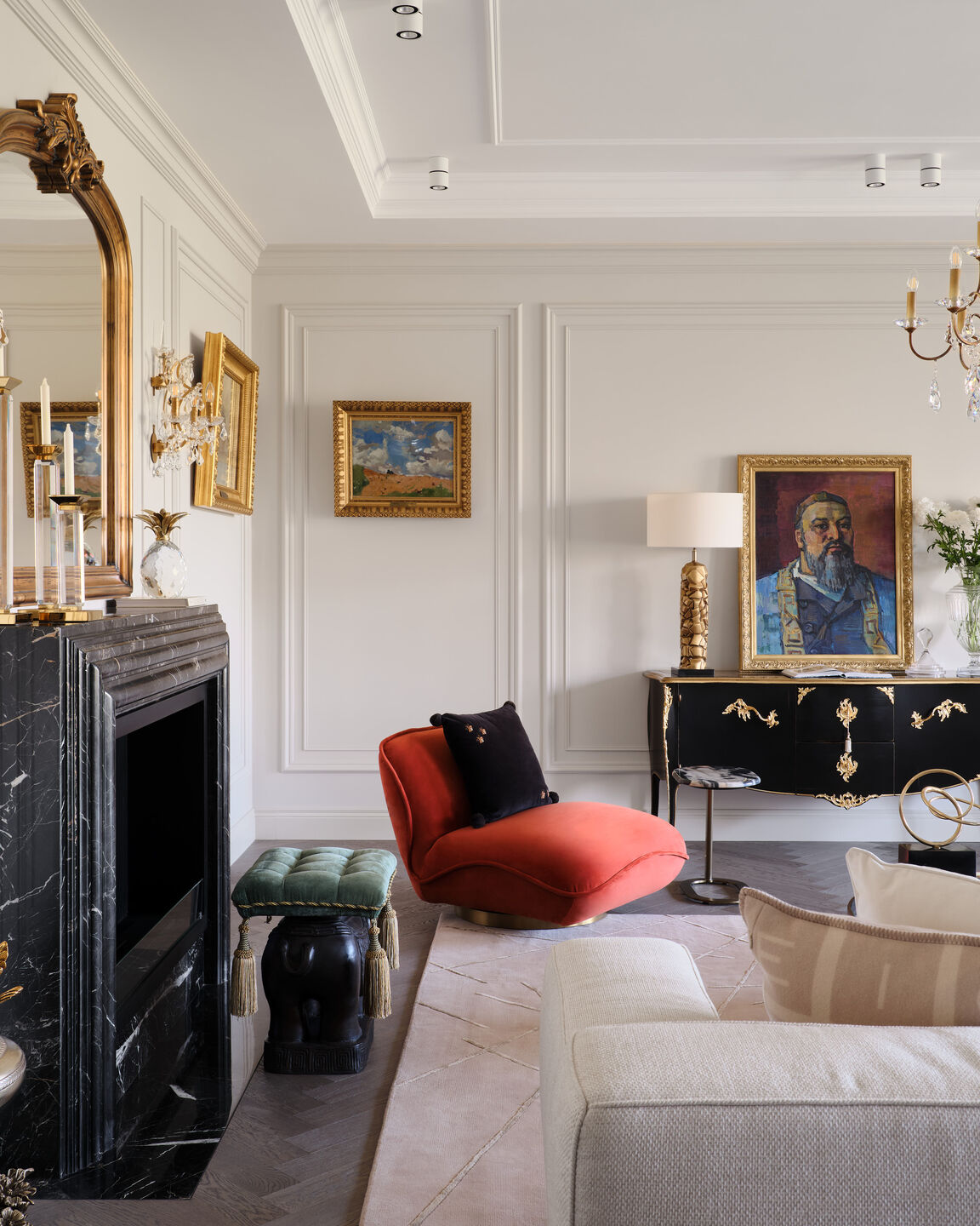 Focus on the fireplace and the neutral furniture group, where an orange velvet armchair serves as a vibrant accent. The room is filled with works by Dutch and Russian artists.