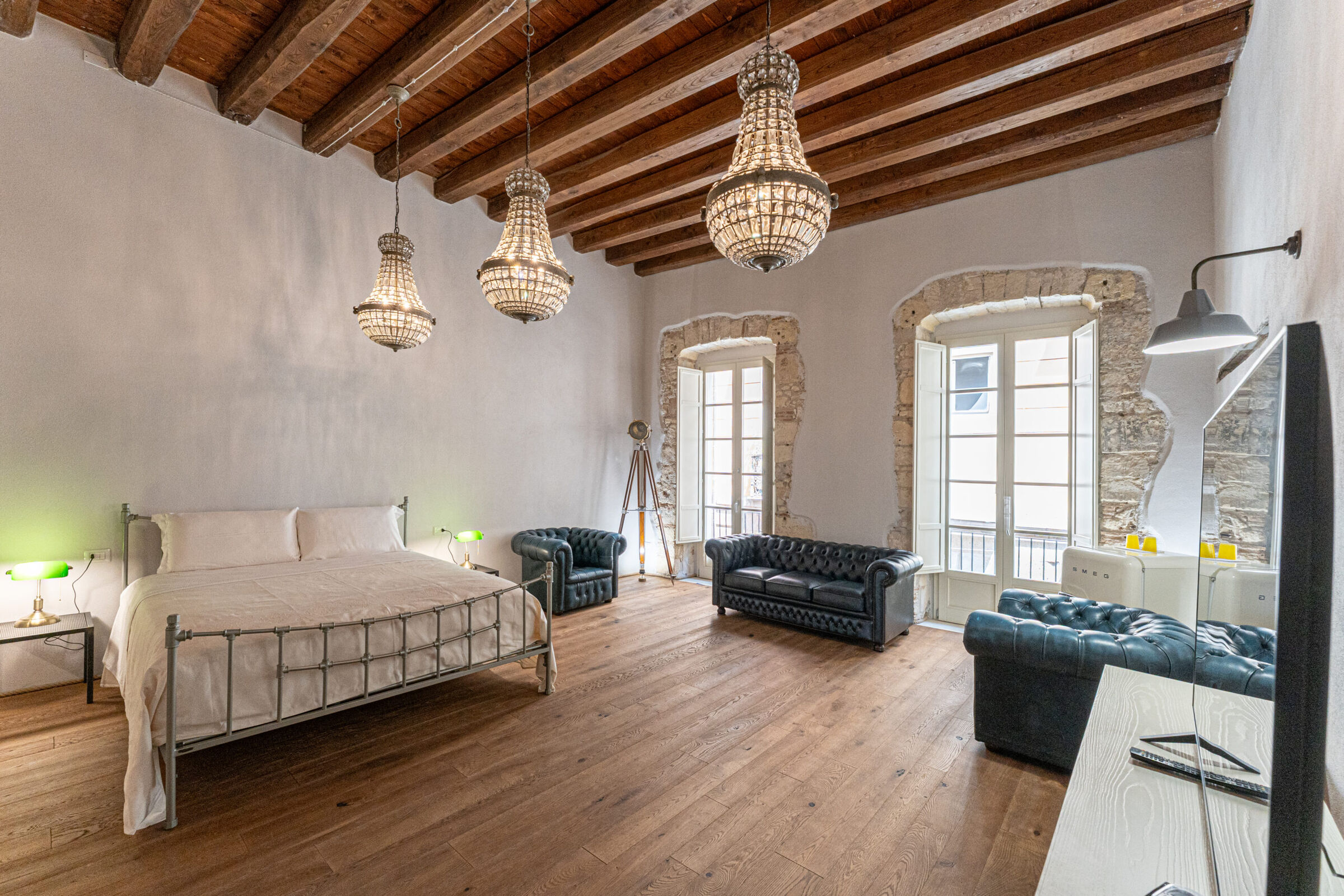 Elegant hotel room in Cagliari with custom metal bed by Volcano and natural materials