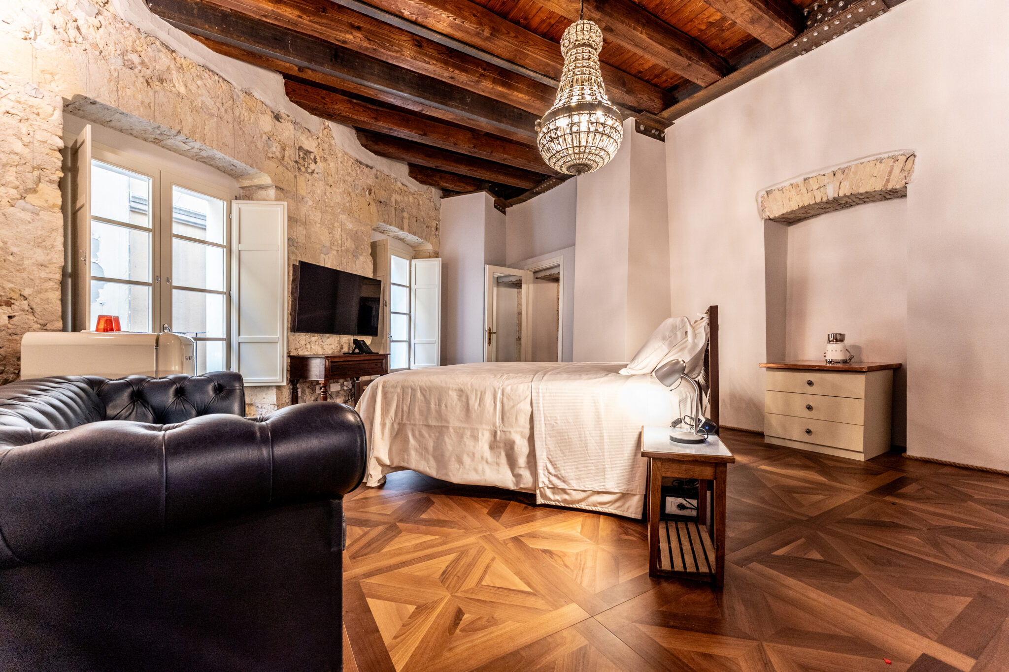 Hotel bedroom featuring handmade iron bed by Volcano, blending comfort with timeless design