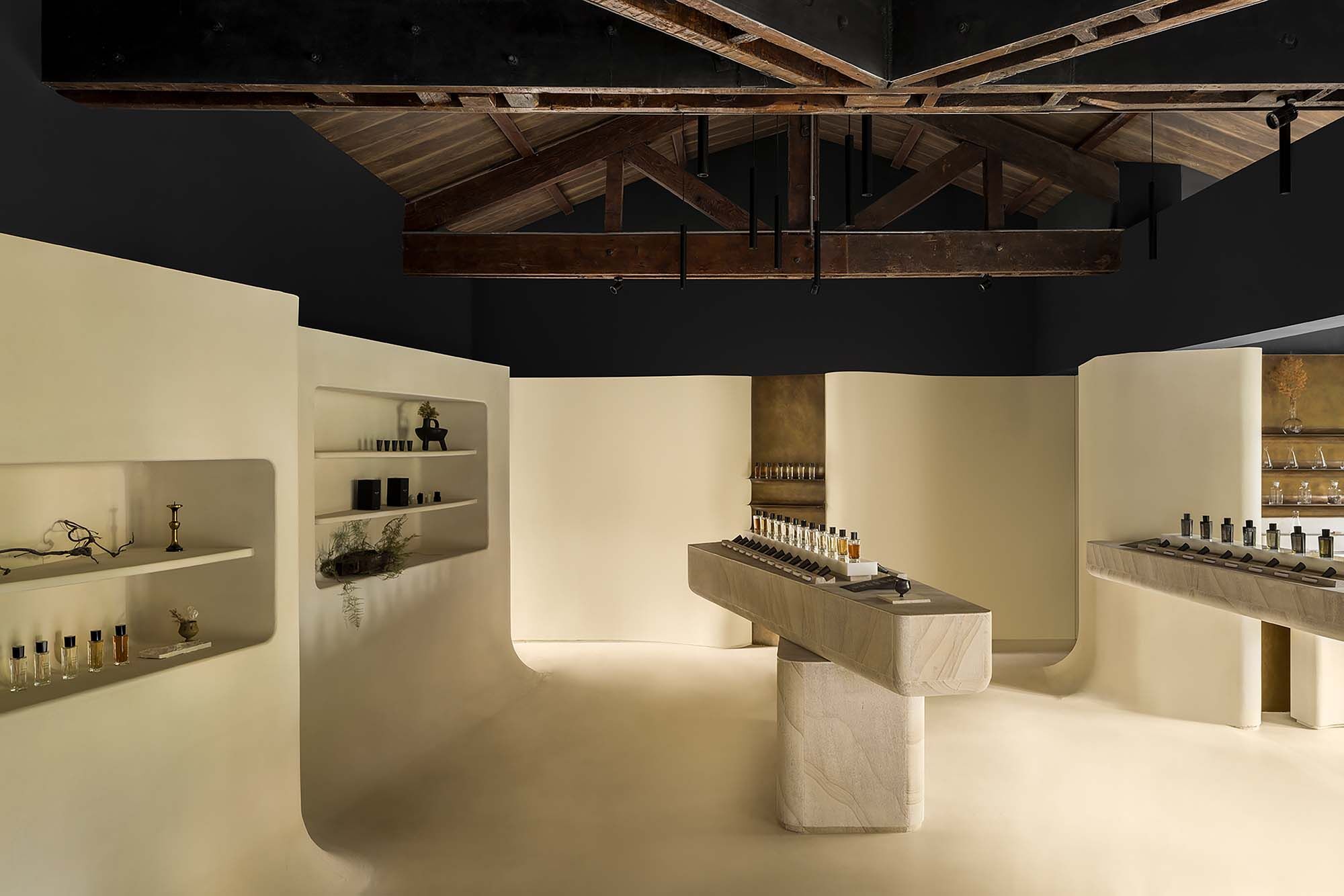 Microcement walls frame the space, while polished natural sandstone slabs define the display counter as the visual centerpiece of the second floor.