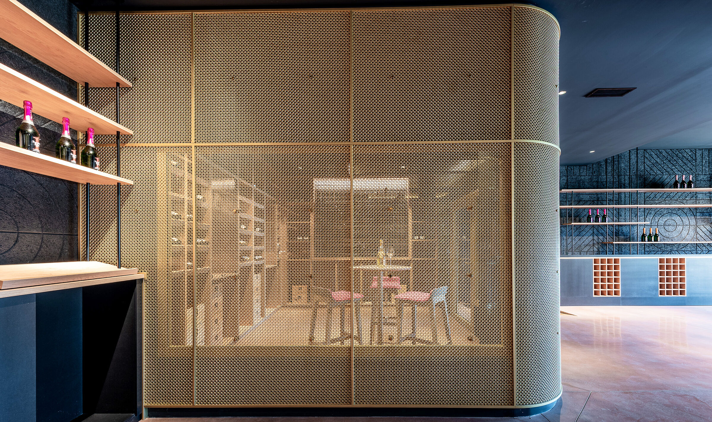 A contemporary wine tasting space features M22-83 brass woven wire mesh as a space divider for a tasting room.