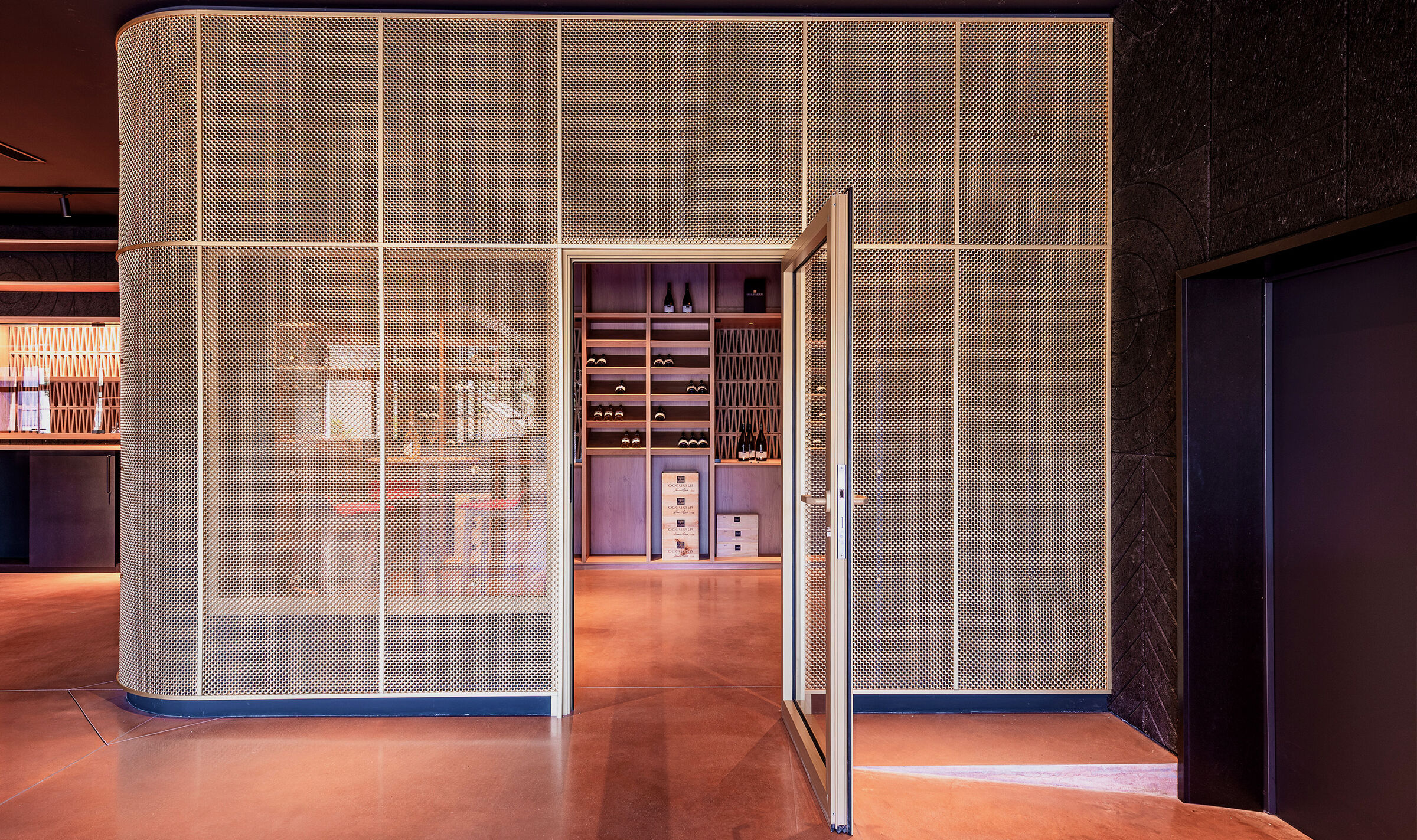 A contemporary wine tasting space features M22-83 brass woven wire mesh as a space divider for a tasting room.