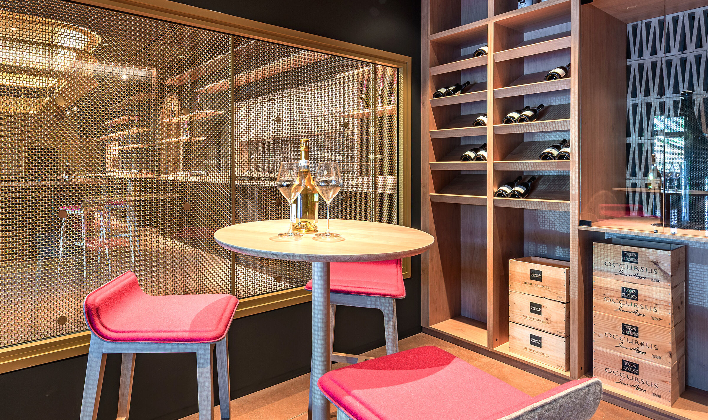 A contemporary wine tasting space features M22-83 brass woven wire mesh as a space divider for a tasting room.