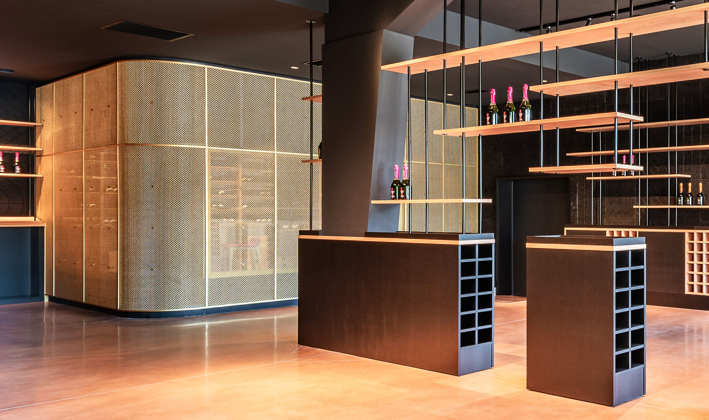 A contemporary wine tasting space features M22-83 brass woven wire mesh as a space divider for a tasting room.