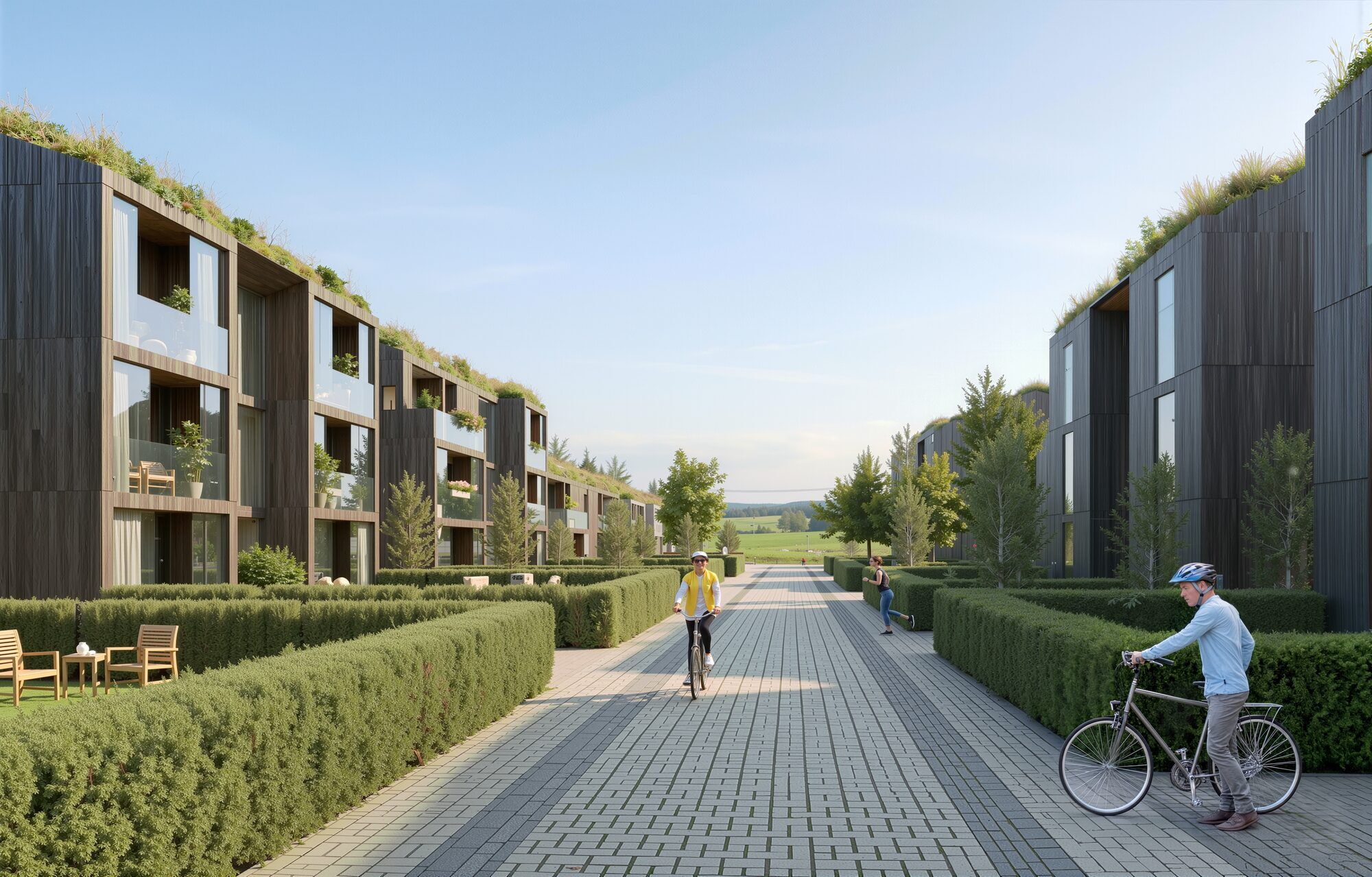 A residential cycle and pedestrian path running between low timber buildings, well-tended hedges and with an unobstructed view of the countryside.