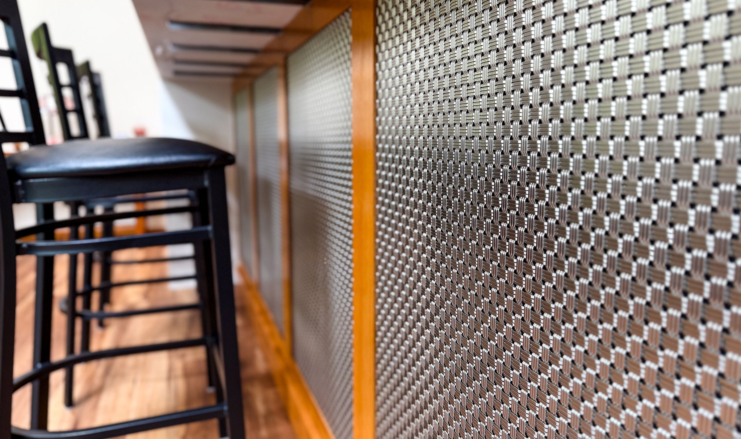 Discover how Banker Wire's M33-2 woven wire mesh adds texture, depth, and sophistication to this custom home bar remodel, creating a striking architectural focal point.