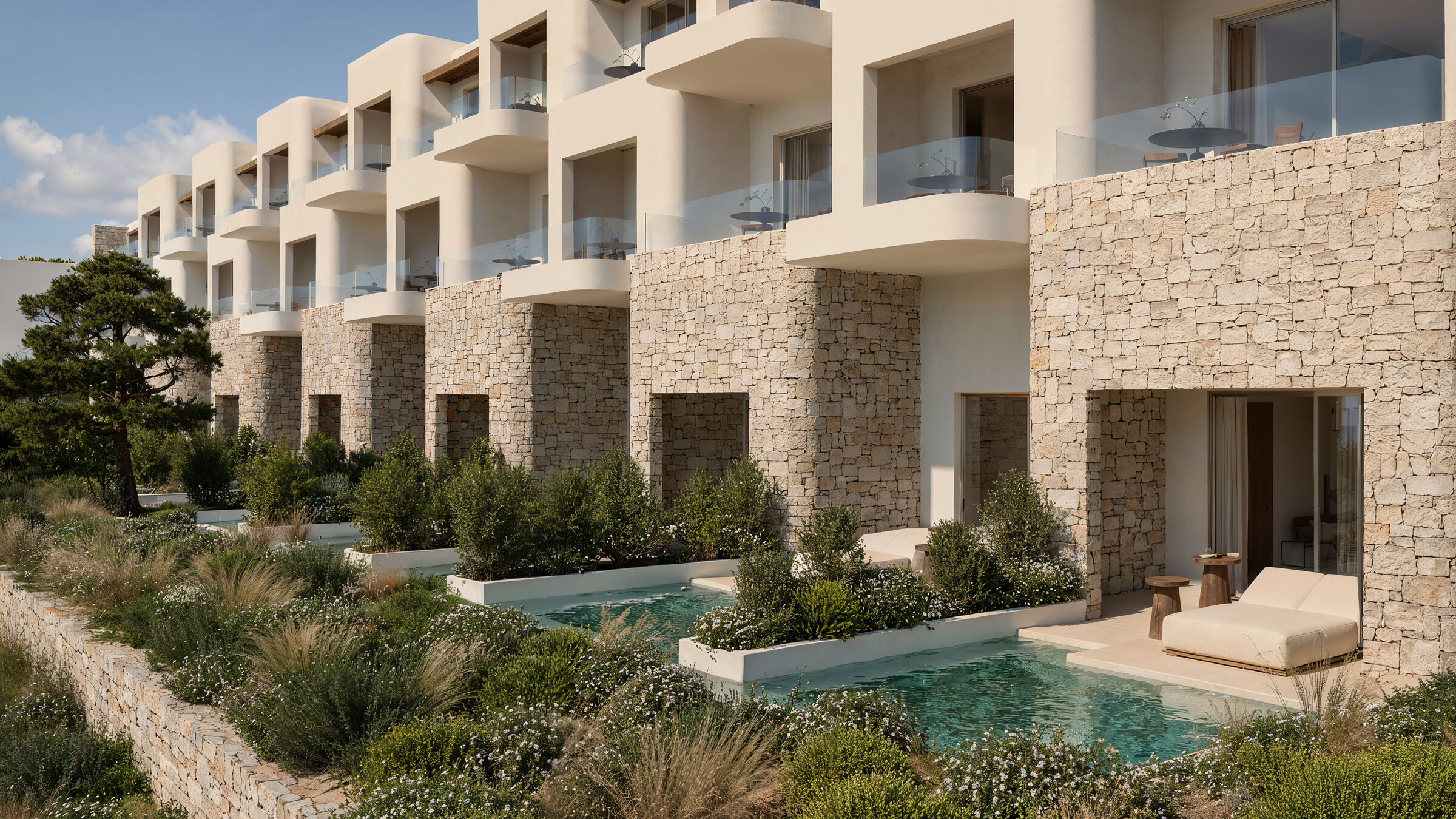 Guestroom façades with private pools, stone walls and integrated landscaping.