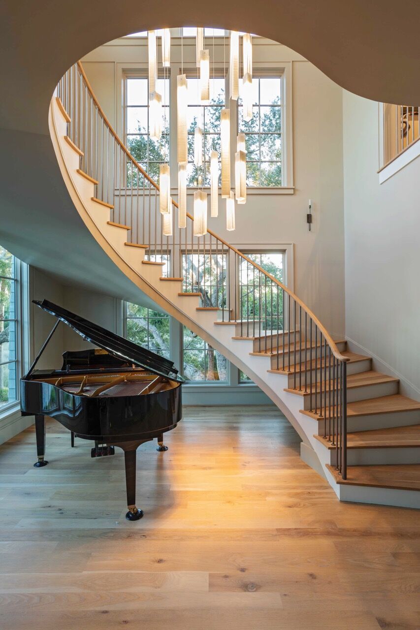 A custom Sunbeam chandelier anchors the grand piano beneath the soaring cathedral ceiling.
