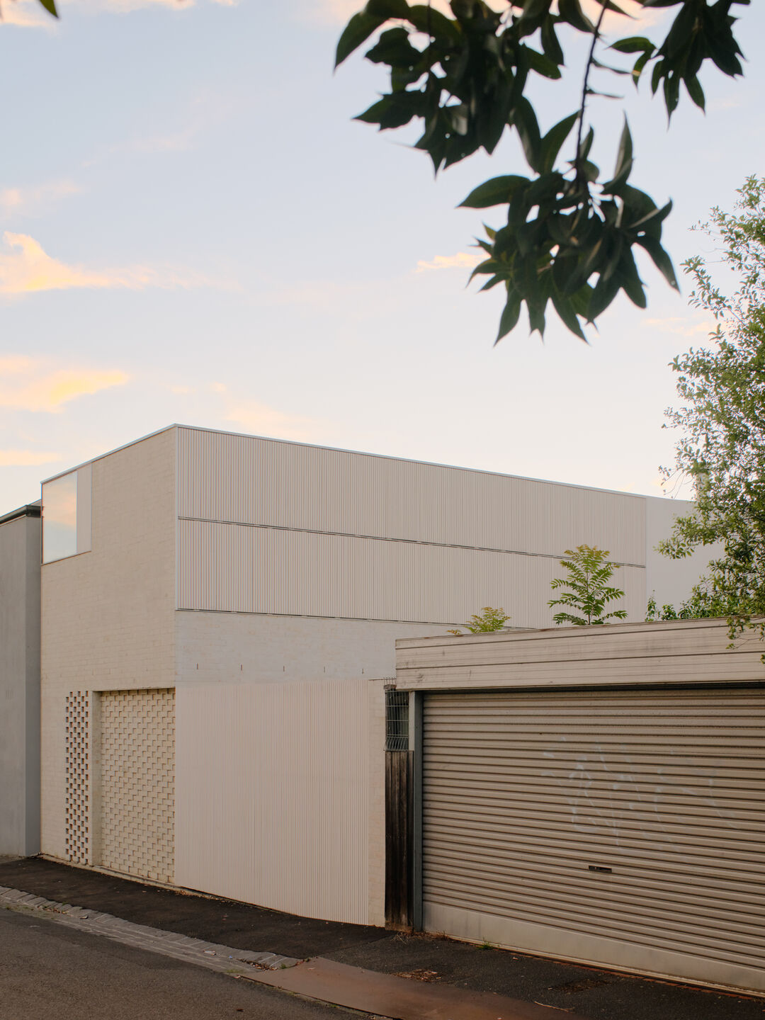 The facade at dusk with all of the operable shutters closed.