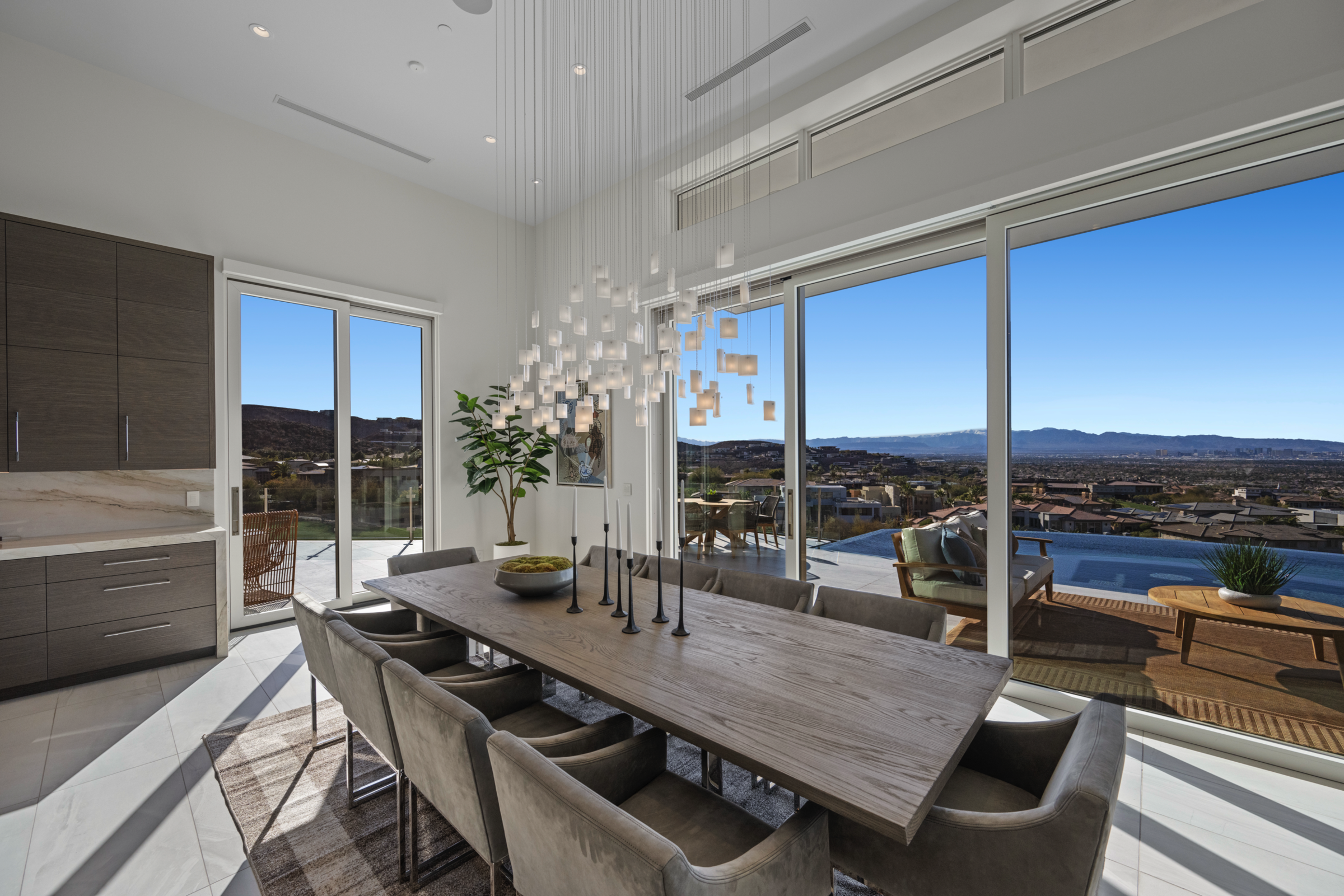 Dining area overlooking the landscape, part of the home’s coordinated lighting collection.