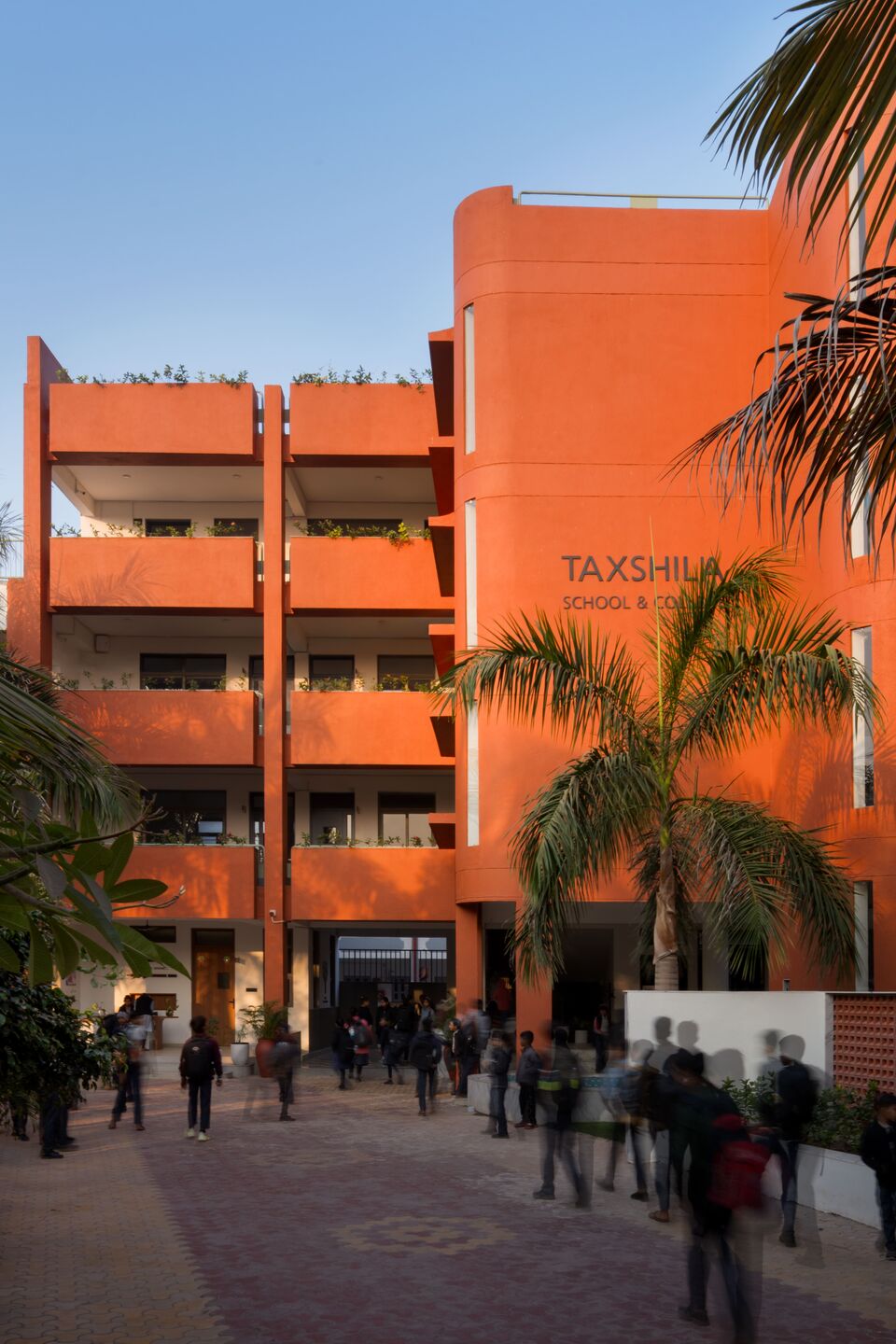 The material palette is rooted in a philosophy of groundedness, humility, and peace. The terracotta-coloured facade draws from the earth of the region — not as decoration, but as an expression of connection to the land.
