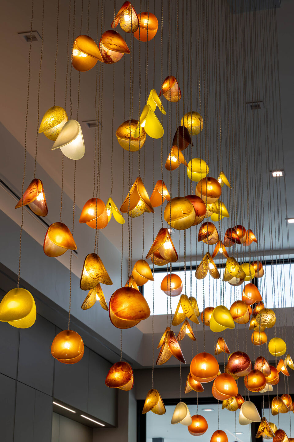 Close-up of the Sunbeam chandelier featuring handcrafted glass in layered amber and warm natural tones.