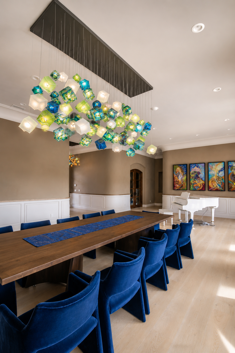 Custom Noya glass chandelier creating a colorful sculptural centerpiece above the dining table.