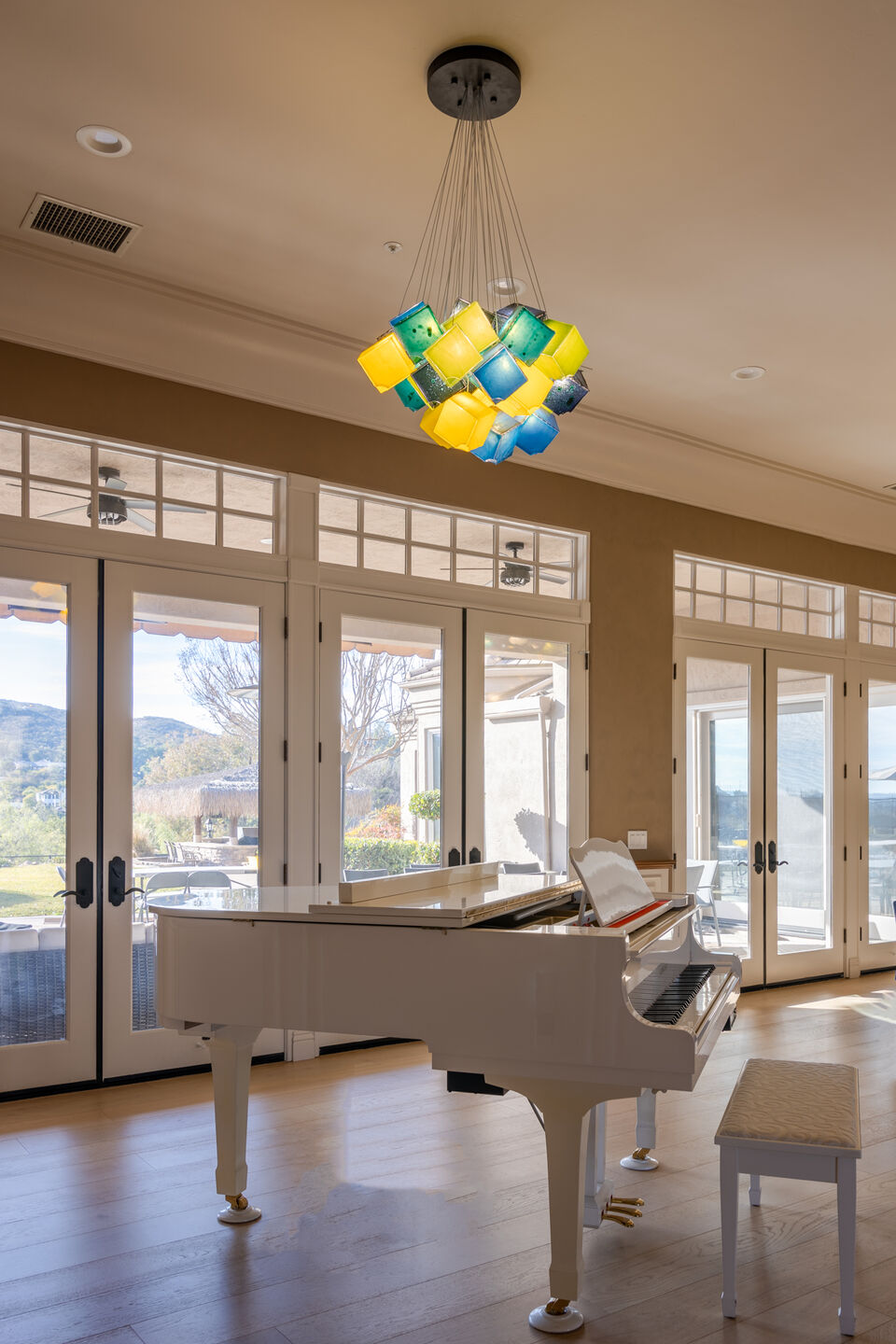 Natural light and handcrafted glass create a bright, art-filled interior overlooking the landscape.