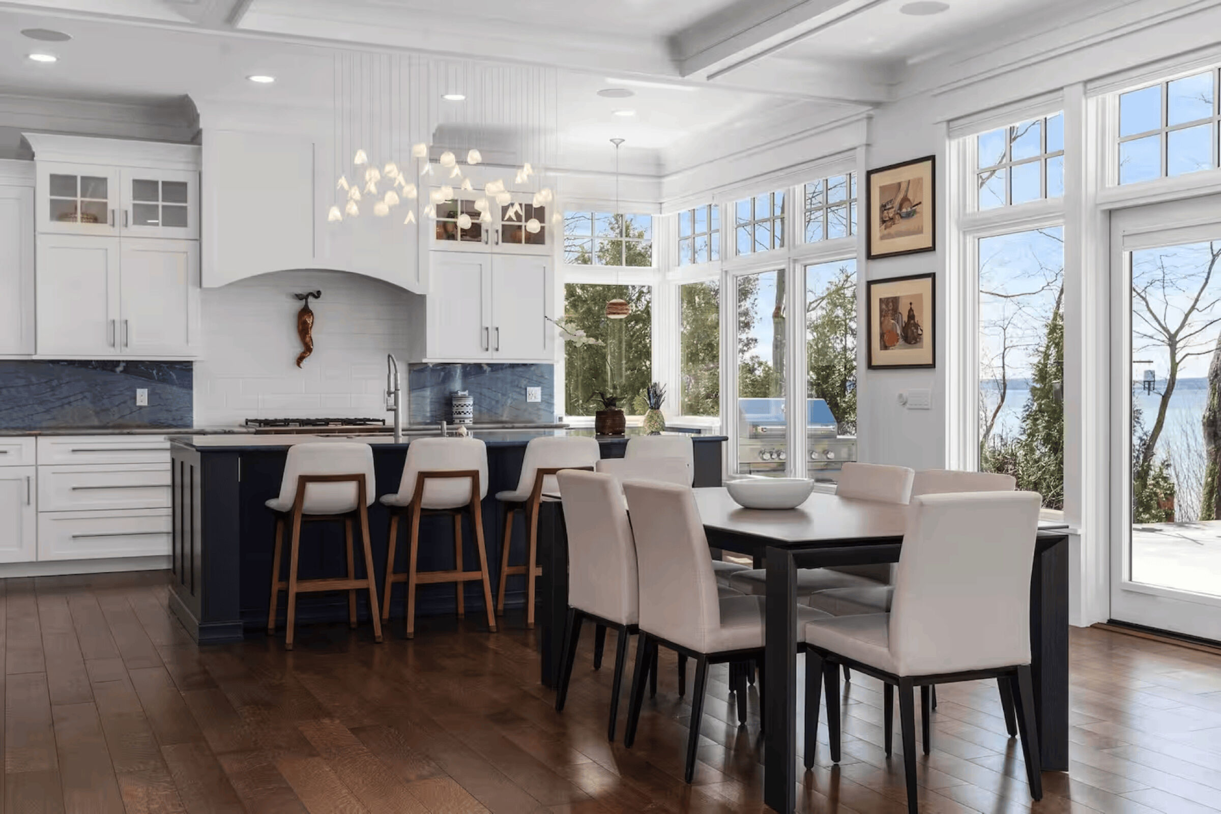 Custom white glass chandelier above the kitchen island, complementing the bright coastal interiors and Lake Michigan views.