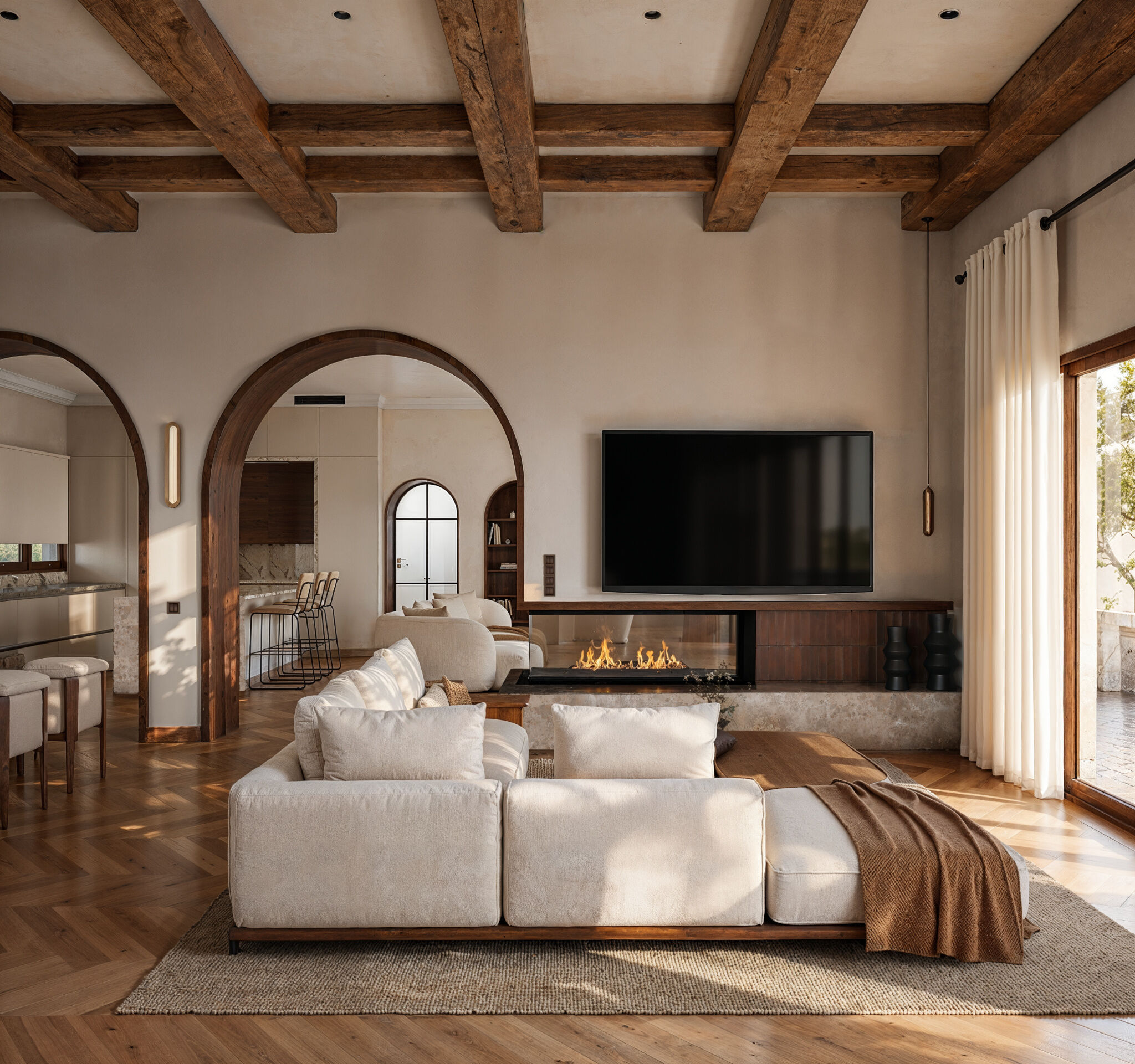 A contemporary living room combines exposed timber beams, natural stone, and an integrated fireplace, creating a warm residential atmosphere inspired by the architectural character of Karpathos.