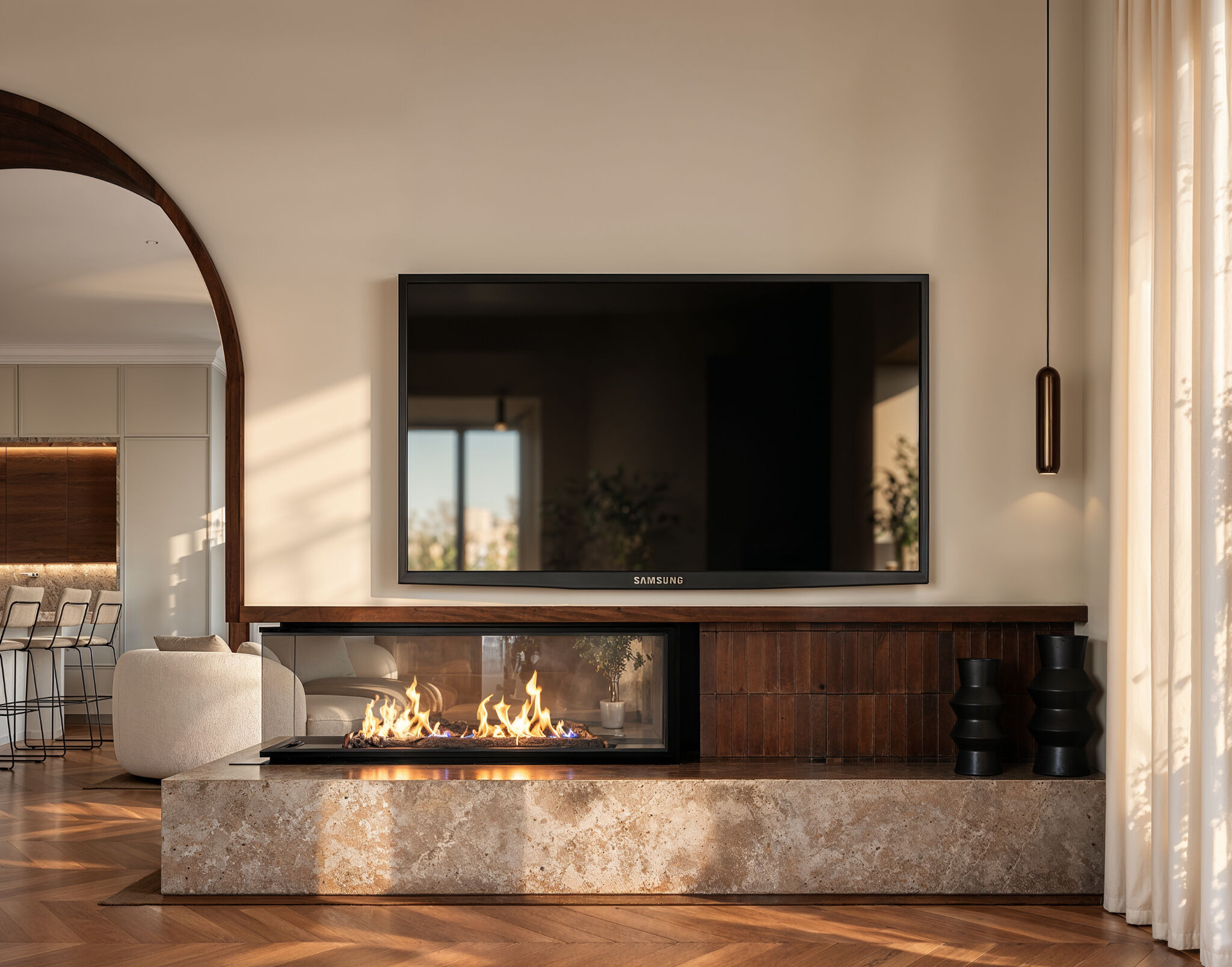 A double-sided fireplace integrated with natural stone and dark timber cabinetry creates a distinctive architectural focal point, connecting the living spaces through warmth and material continuity.